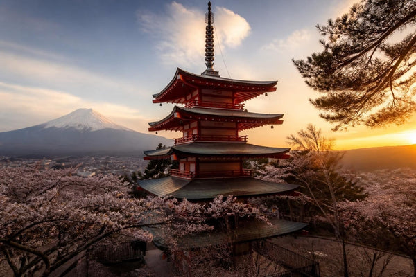 The vermilion five-storey pagoda of Chureito with Mount Fuji rising behind it under a clear sky in Japan