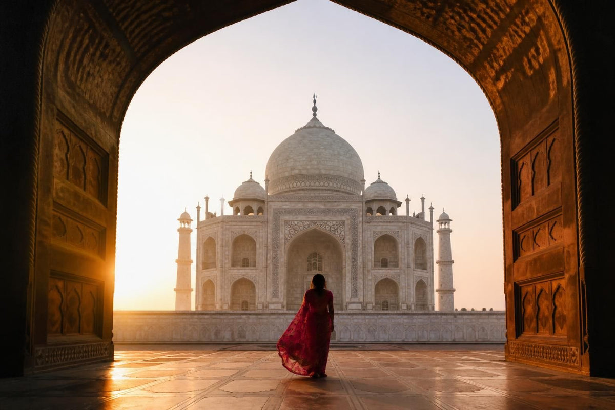 The Taj Mahal at sunrise in Agra, its white marble dome reflected in the long water channel, India